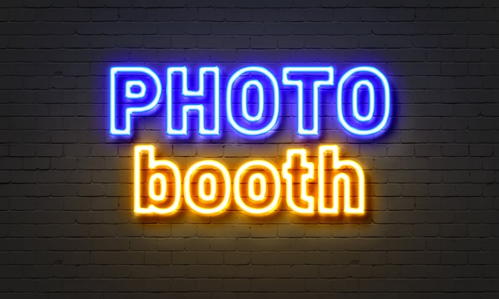 Photo Booth Neon Sign on Brick Wall Background.