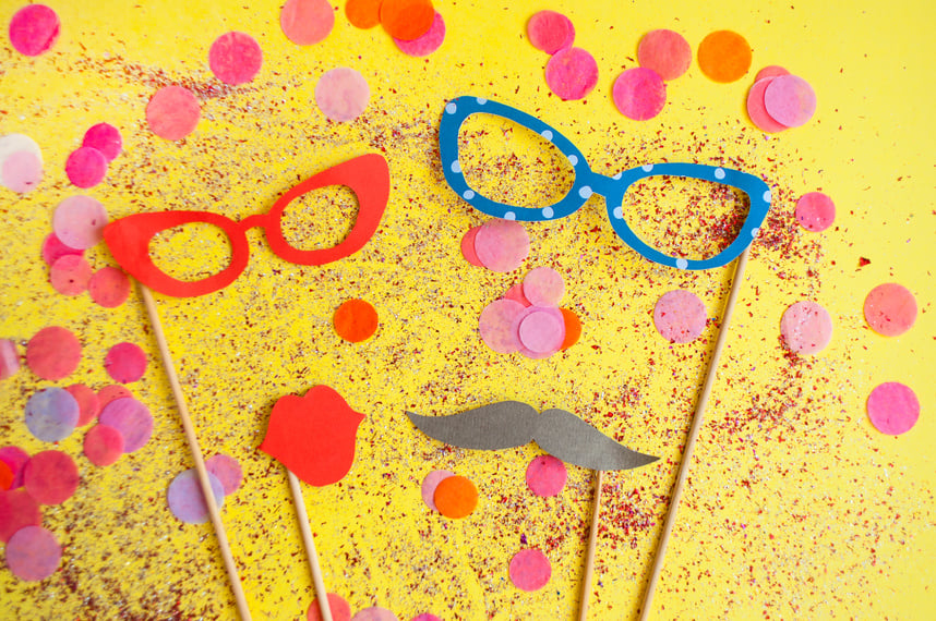 Colorful photo booth props on yellow background.